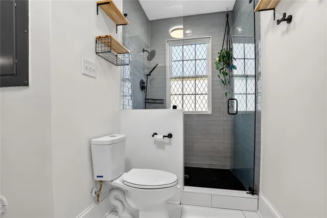 a bathroom with a toilet a window and shower