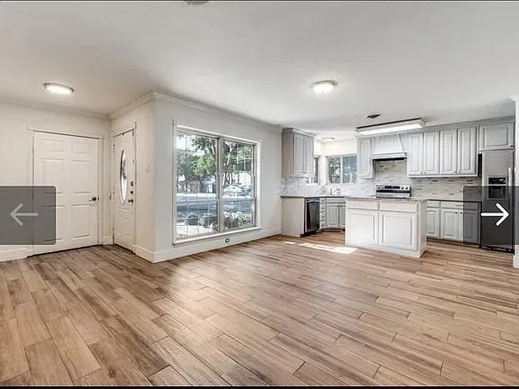 a view of kitchen with wooden floor and electronic appliances