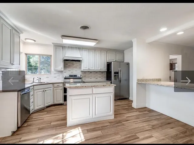 a view of kitchen with wooden floor and electronic appliances