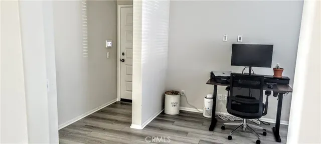 a view of a workspace with furniture and wooden floor