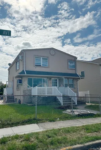 a view of house with a big yard and a large tree