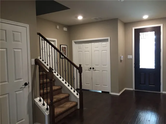 a view of a hallway with wooden floor and stairs