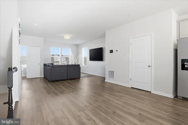 a view of a livingroom with wooden floor and a flat screen tv