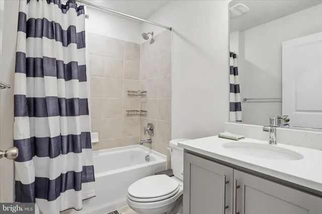 a bathroom with a sink a toilet a shower curtain and a mirror