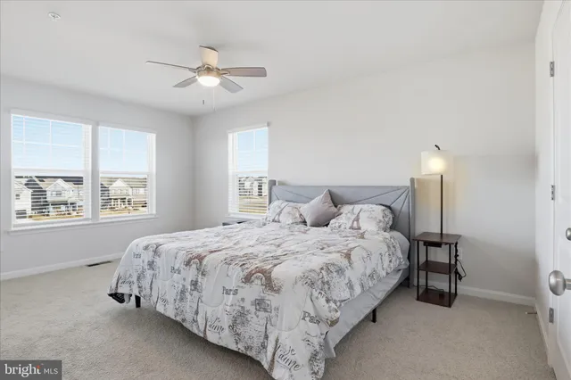 a large bed sitting in a bedroom next to a window and a chandelier