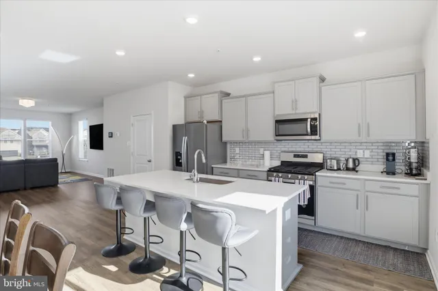 a kitchen with a sink a stove a refrigerator and white cabinets