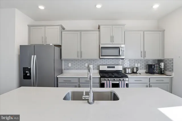 a kitchen with stainless steel appliances a refrigerator a stove a sink a microwave and cabinets