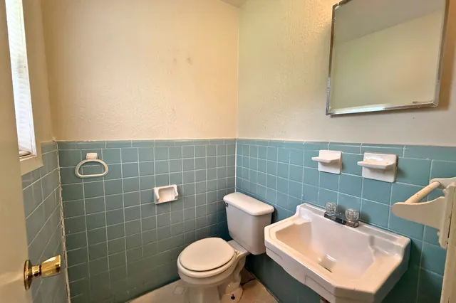 a bathroom with a sink a toilet and a mirror