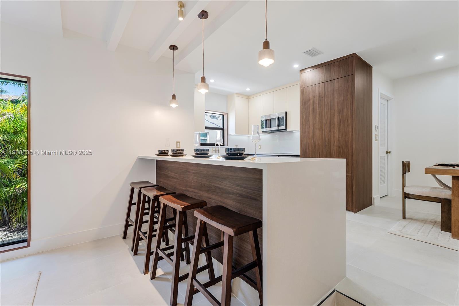 1244 Southwest 14th Street Miami, FL 33145 - Photo 22 of 63 a kitchen with a table chairs refrigerator and microwave