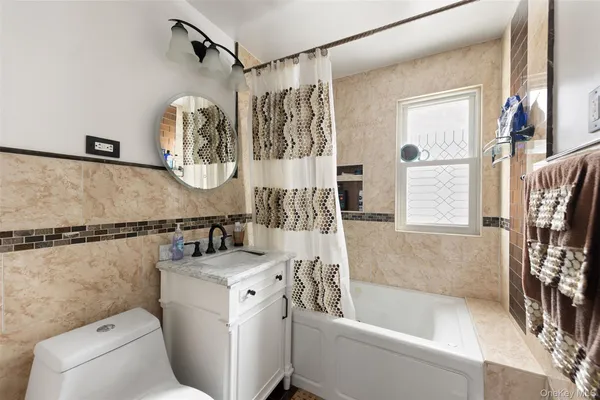 a bathroom with a tub sink and mirror