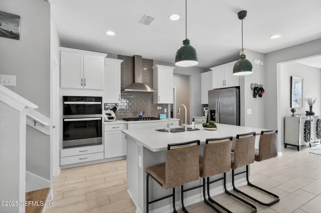 a kitchen with kitchen island a stove a table and chairs in it