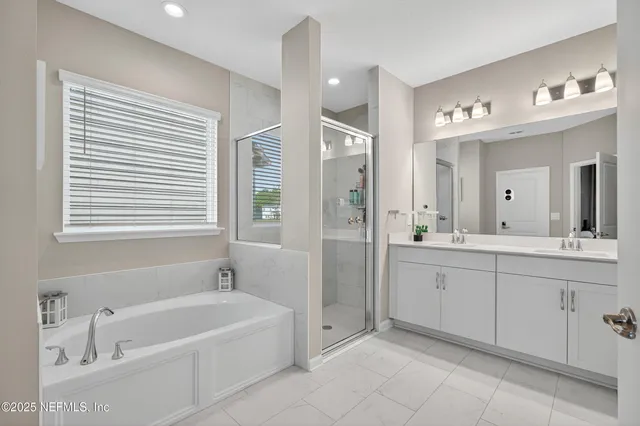 a spacious bathroom with a bathtub sink and mirror