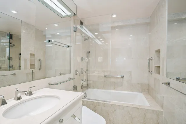 a bathroom with a tub sink shower and a mirror