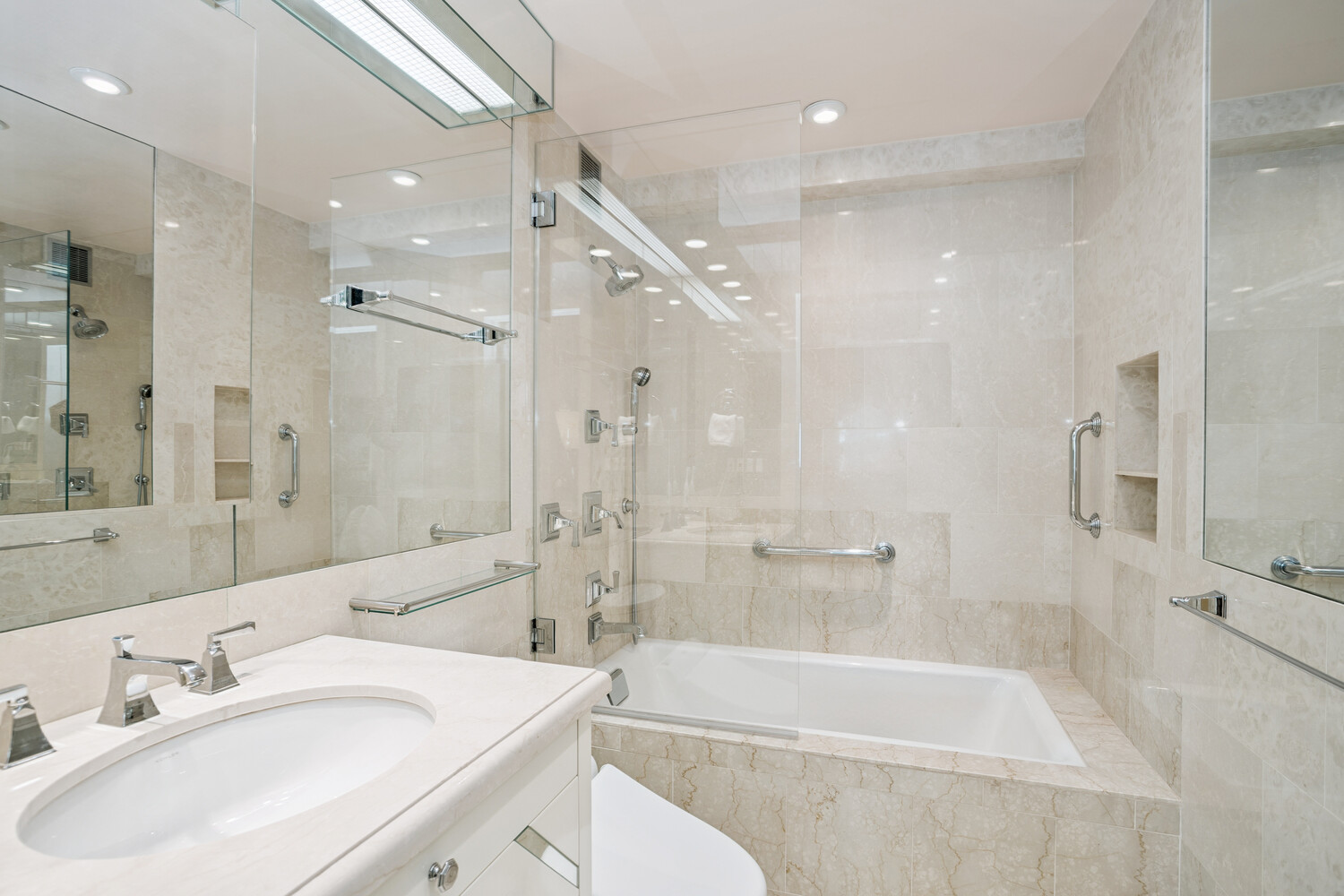 860 5th Avenue, Unit 2E Manhattan, NY 10065 - Photo 7 of 10 a bathroom with a tub sink shower and a mirror