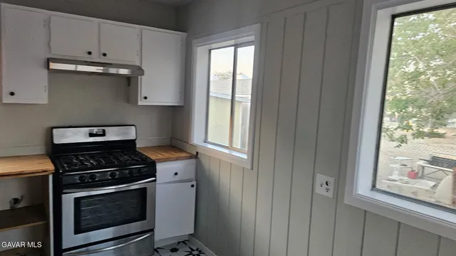 a kitchen with granite countertop cabinets stainless steel appliances and a window