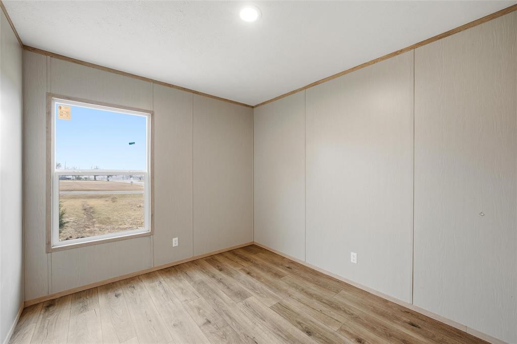 224 Derek Road Eddy, TX 76524 - Photo 18 of 24 an empty room with wooden floor and windows