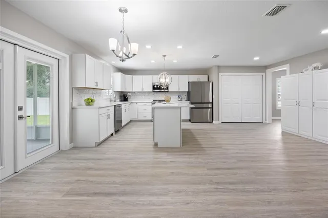 a kitchen with white cabinets appliances and a sink