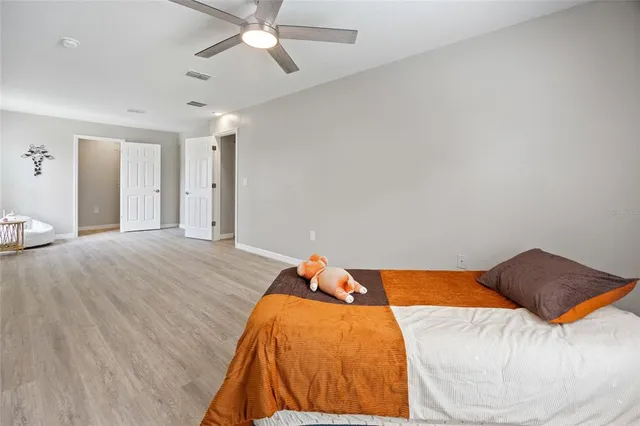 a room with a bed and wooden floor