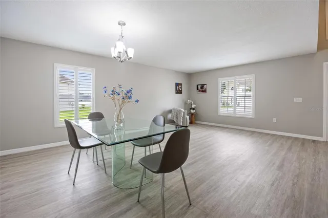 a view of a dining room with furniture a chandelier and wooden floor