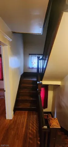 a view of staircase with wooden floor and chair