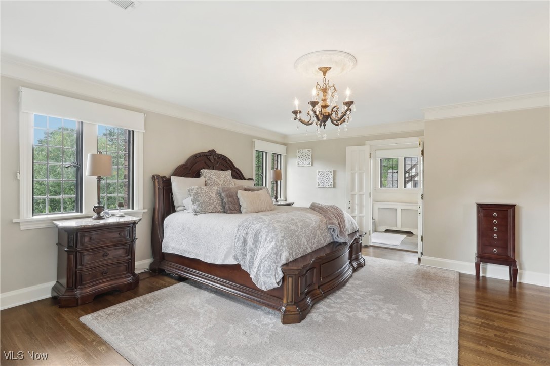 875 Mayfair Road Akron, OH 44303 - Photo 24 of 40 Bedroom with a notable chandelier, dark hardwood / wood-style flooring, ensuite bathroom, and crown molding