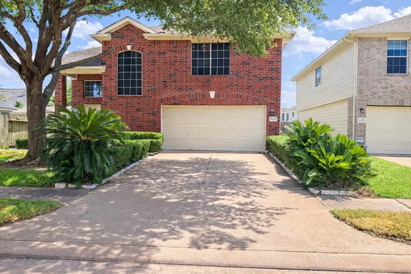 a front view of a house with a yard and a garage