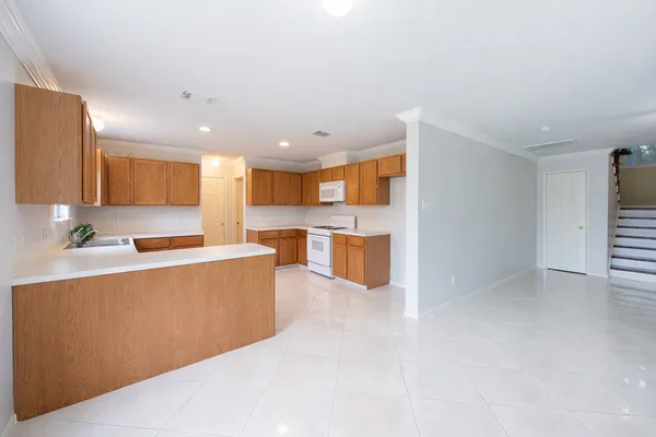 a large kitchen with stainless steel appliances granite countertop a refrigerator and a sink