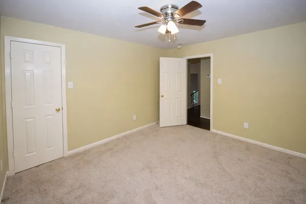 an empty room with chandelier fan