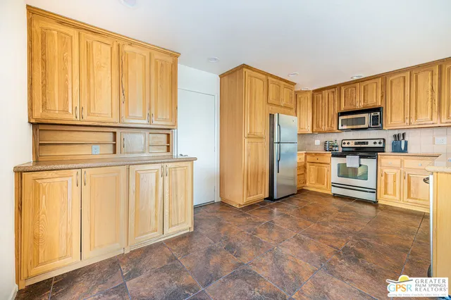 a kitchen with stainless steel appliances a refrigerator and a stove top oven