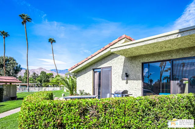 a view of a chair and table in backyard of the house