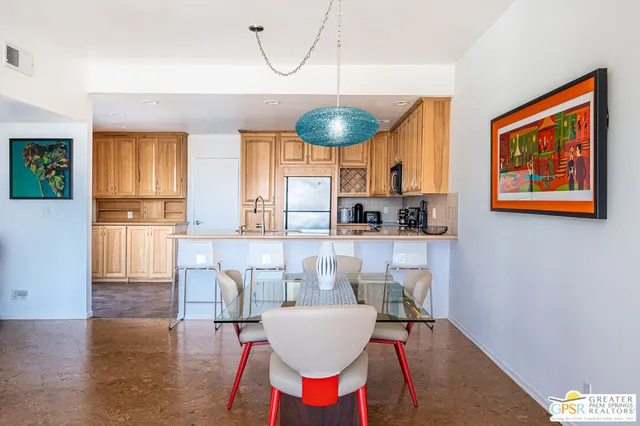 a kitchen with stainless steel appliances kitchen island granite countertop a table and chairs with wooden floor