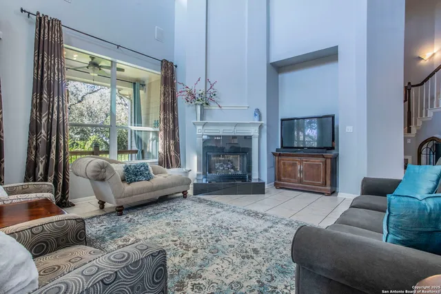a living room with furniture a large window and a fireplace