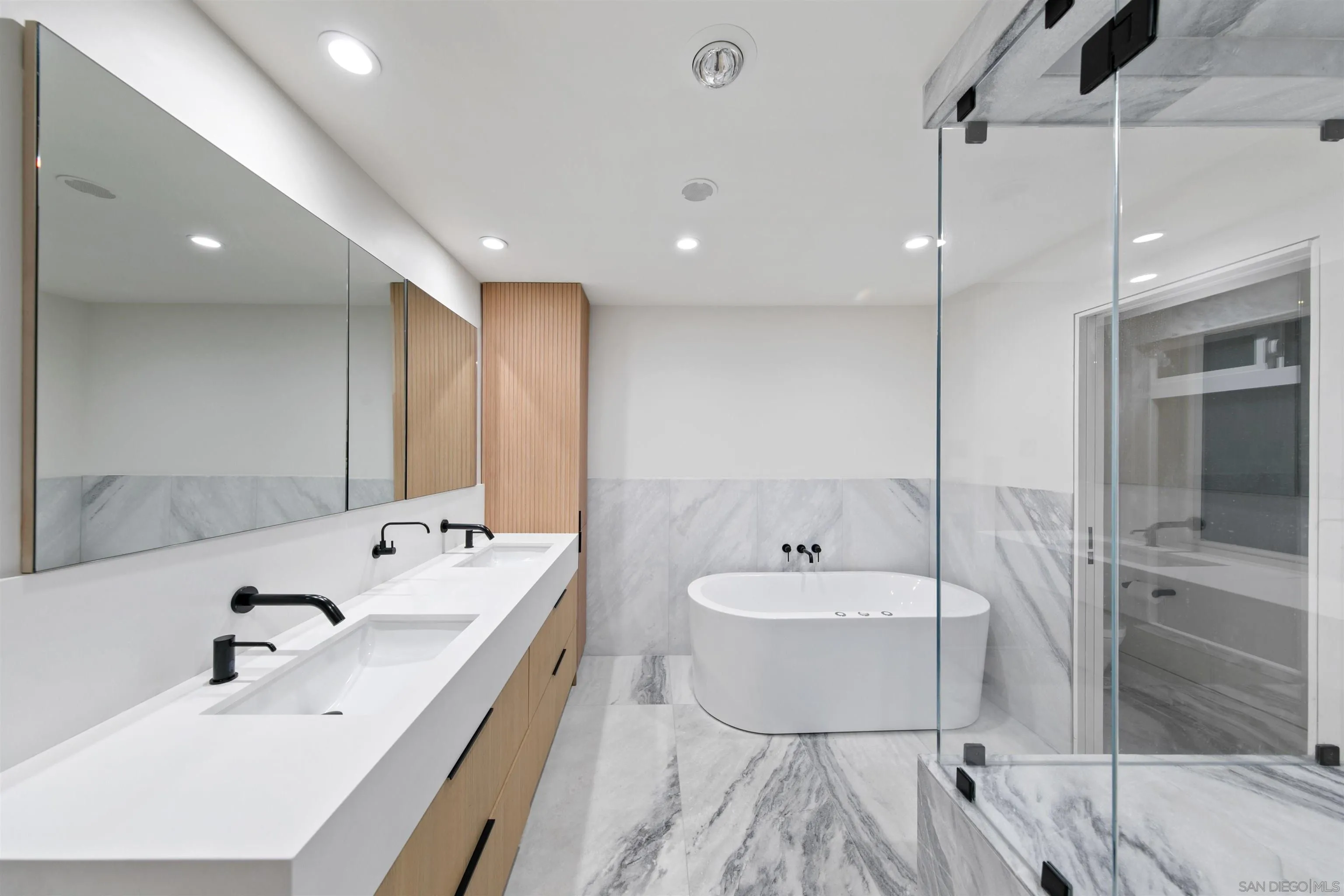 5675 Soledad Mountain Road La Jolla, CA 92037 - Photo 25 of 74 a spacious bathroom with a double vanity sink a mirror and a bathtub