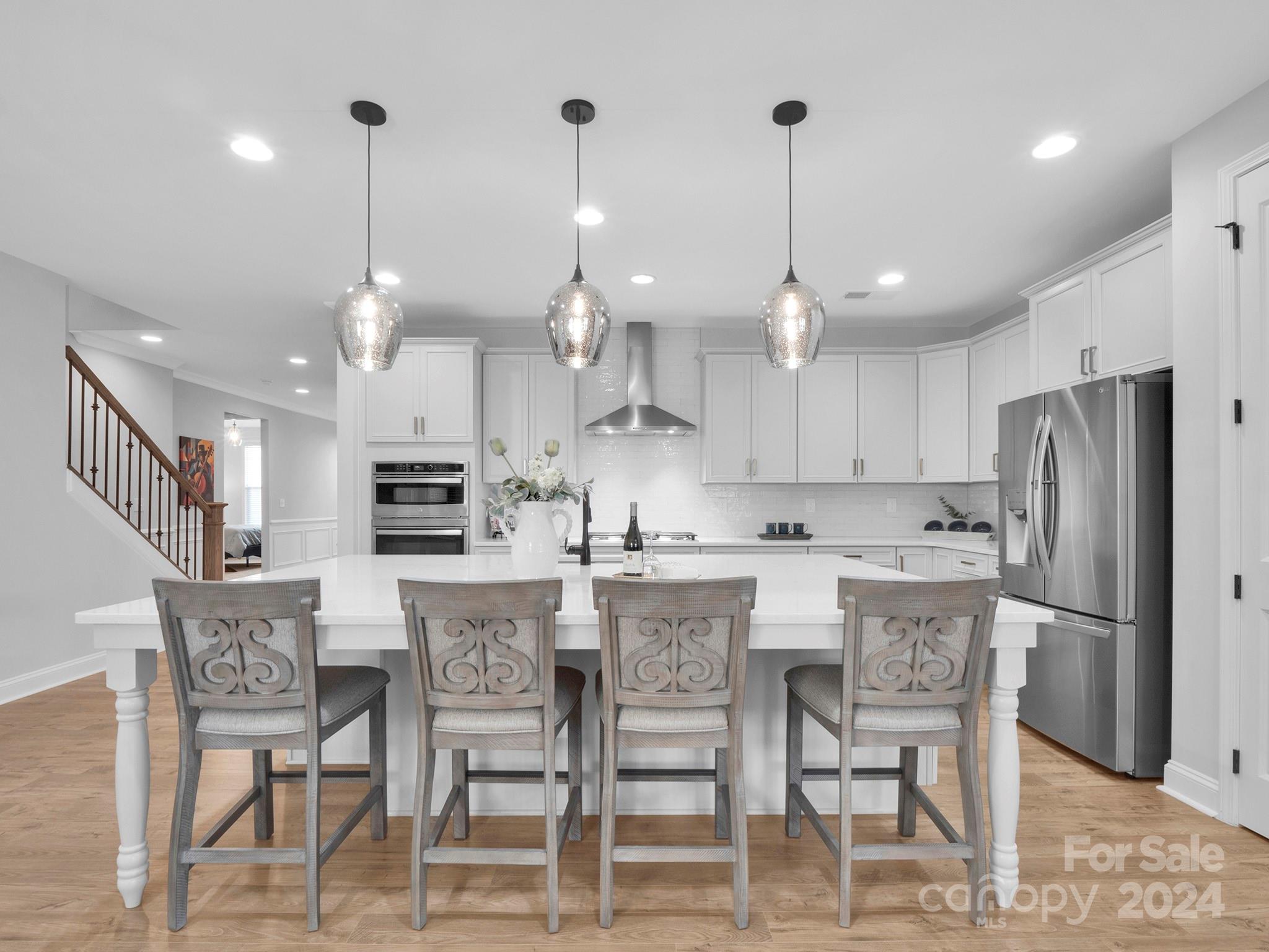 4011 Charlton Road Fort Mill, SC 29715 - Photo 13 of 48 a kitchen with kitchen island a dining table chairs and white cabinets