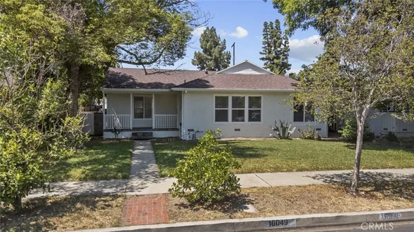 a view of a house with a yard and large tree