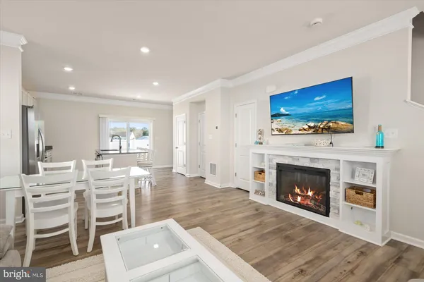 a living room with wooden floor and a fireplace