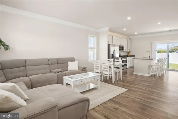 a living room with furniture and view of kitchen