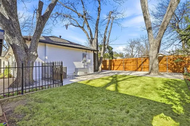 a view of a house with backyard and tree