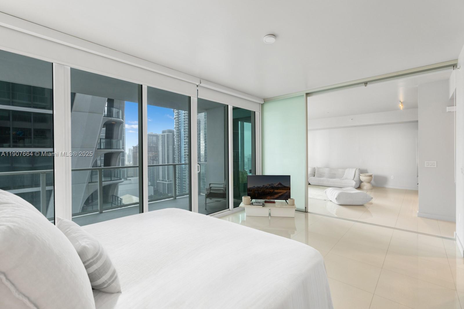 1040 Biscayne Boulevard, Unit 2908 Miami, FL 33132 - Photo 4 of 14 a bedroom with a bed and a mirror