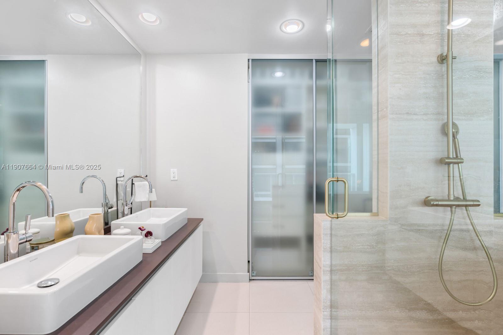 1040 Biscayne Boulevard, Unit 2908 Miami, FL 33132 - Photo 7 of 14 a bathroom with a double vanity sink and a mirror