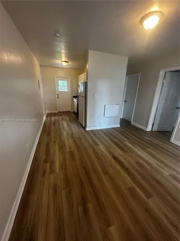 a view of empty room with wooden floor