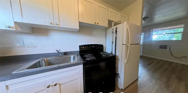 a kitchen with refrigerator and cabinets