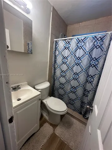 a white toilet sitting next to a shower curtain