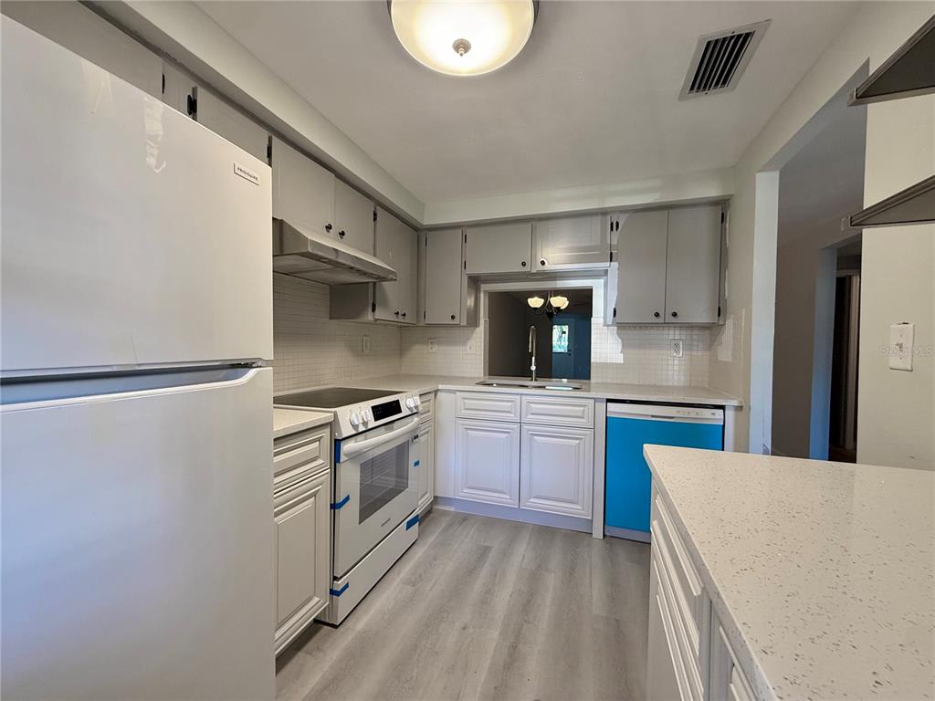 4408 Sunstate Drive New Port Richey, FL 34652 - Photo 8 of 31 a kitchen with granite countertop a sink stove and refrigerator