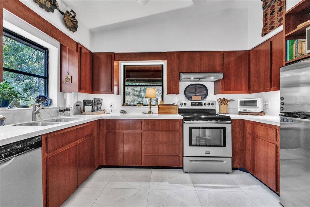8056 Southwest Horse Creek Road Arcadia, FL 34266 - Photo 27 of 42 a kitchen with stainless steel appliances granite countertop a stove a sink dishwasher and a microwave oven with cabinets