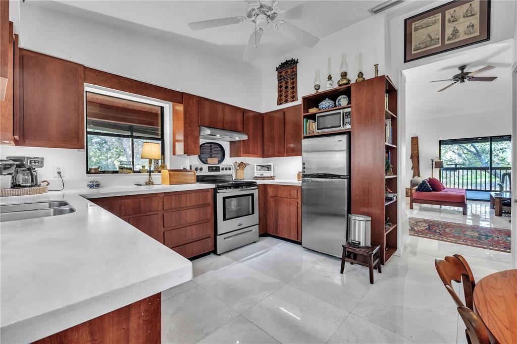 8056 Southwest Horse Creek Road Arcadia, FL 34266 - Photo 29 of 42 a kitchen with stainless steel appliances granite countertop a stove top oven a sink dishwasher a dining table and chairs with wooden floor