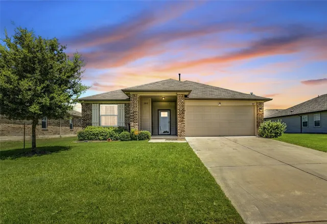 a front view of a house with a garden and yard