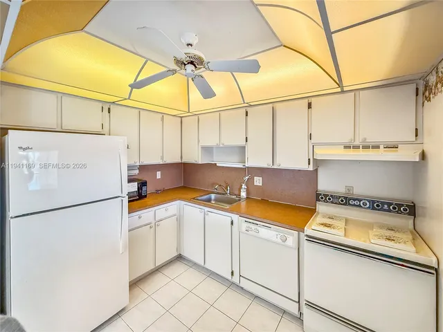 a kitchen with a sink a refrigerator and cabinets