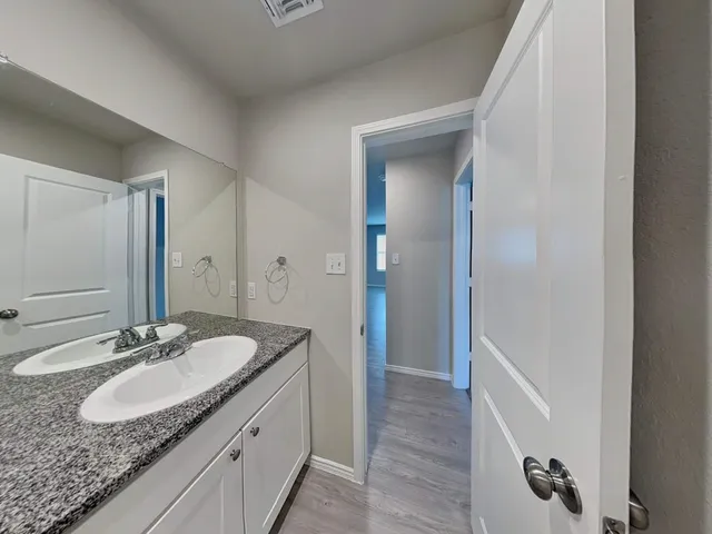 a bathroom with a granite countertop sink and a mirror