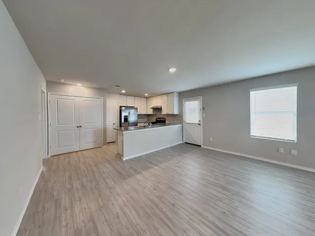a view of a kitchen with wooden floor and windows